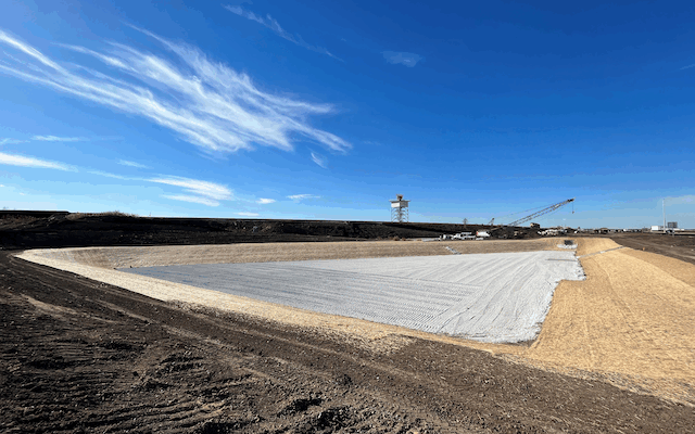 Wide angle of construction site covered in straw and grey material
