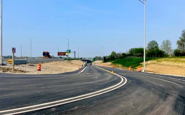 Newly paved road lined with orange barrels